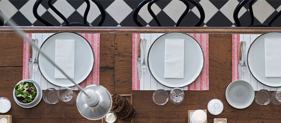 Long restaurant table with red and white stripe placemats